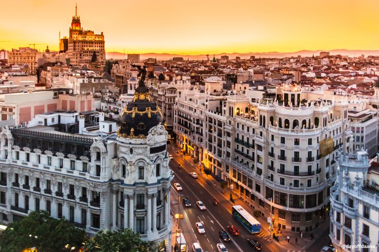 Gran Vía ao entardecer em Madrid, com vista das fachadas iluminadas e movimento nas ruas – excelente opção para quem adora fazer compras na cidade