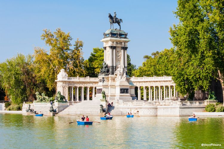 parque do Retiro em Madrid, uma das melhores opções do que fazer em Madrid, mostrando o grande estanque com pessoas ao redor e barcos no lago em um dia ensolarado