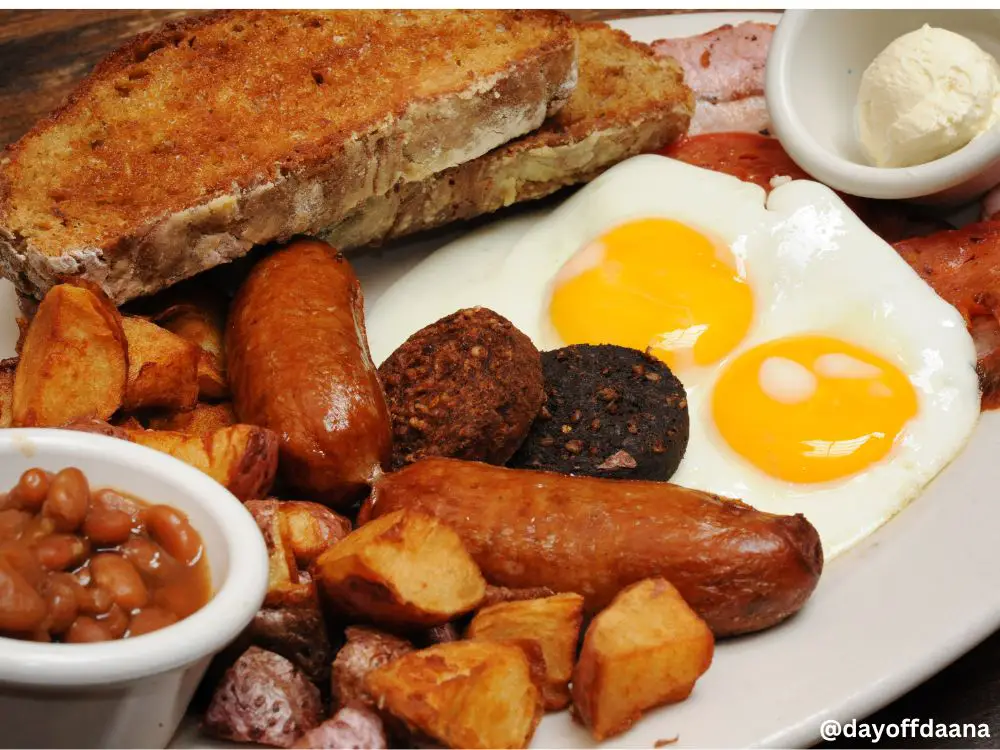 Alt= Irish Breakfast - o café da manhã, especialmente depois de uma boa noite em um pub irlandês. O Irish Breakfast é um prato farto, composto por bacon, ovos, linguiças, tomates grelhados, feijão em molho de tomate e torradas, geralmente acompanhado de chá ou café