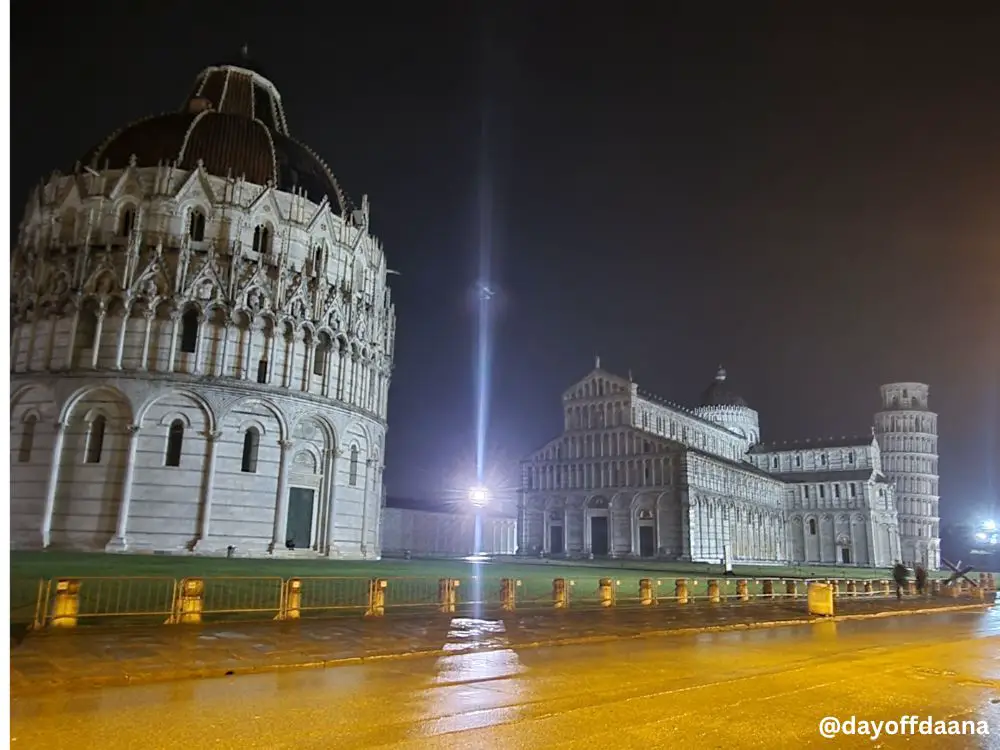 Alt= Vista de Pisa a noite, mostrando duomo, cathedral e torre.