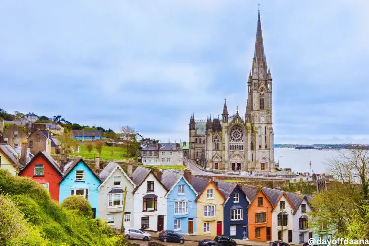 Alt=casas coloridas e bem baixas na frente e catedral atras, grande e monumental e proxima ao porto.