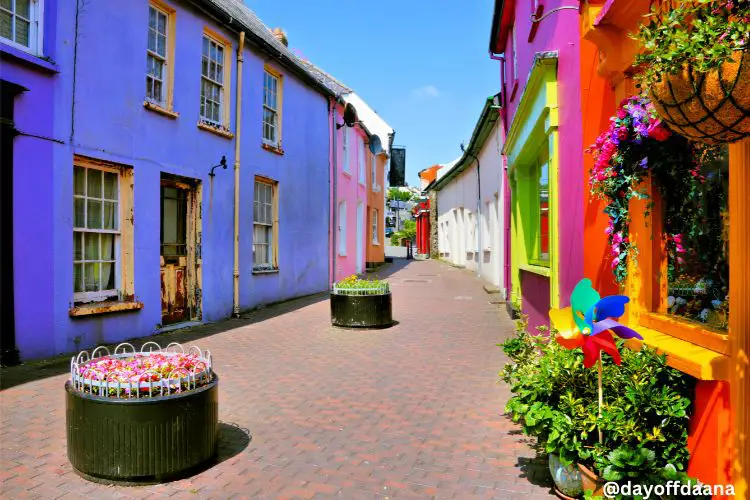 Alt= casas como cores e faixadas chamativas, baixas e mesmo estilo arquitetonico.