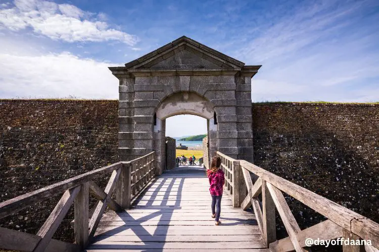 kinsale Charles Fort - foto mostra menina na entrada do fort, onde se ve de fundo paissagem para o mar