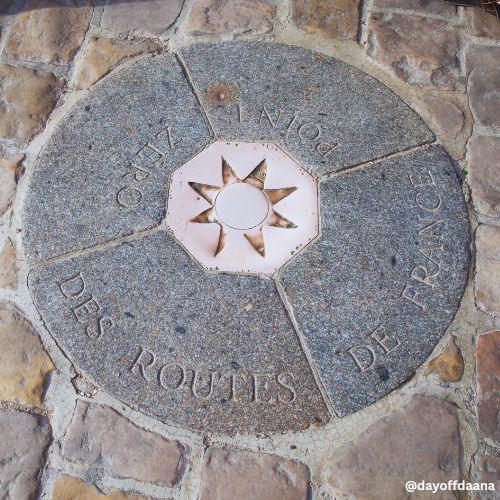 Alt: Mostrando o ponto zero de Paris no chão, próximo à Catedral de Notre-Dame – um local histórico e simbólico da cidade.