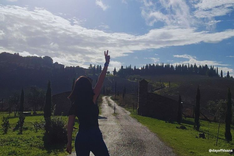 Viajar_sozinha_italia Foto típica da Toscana, fazendo sinal de paz em frente à paisagem. Viajar sozinha é bom!