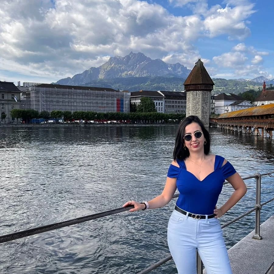 Lucerna ao fundo, eu na frente olhando para foto de azul com a mao na cintura.