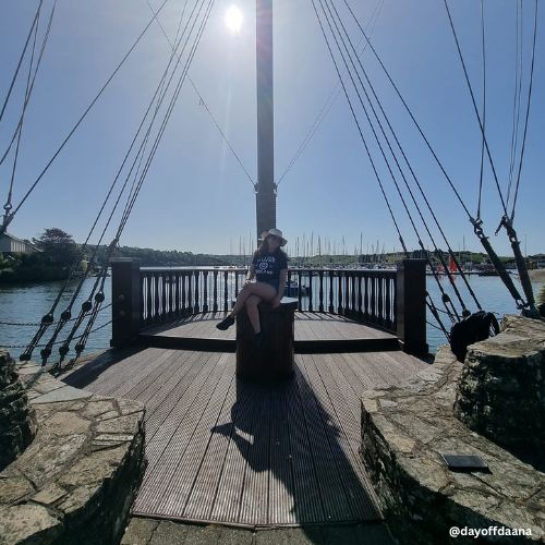 Estou sentada em um ponto de Kinsale que consigo ver a orla e os barcos, antes da caminhada ate a praia em cork.
