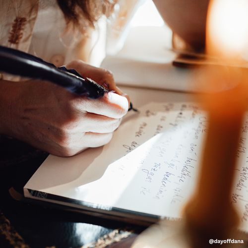 pessoa escrevendo a mao com vela ao lado, remetendo a escrita do blog de viagem e porque o ler