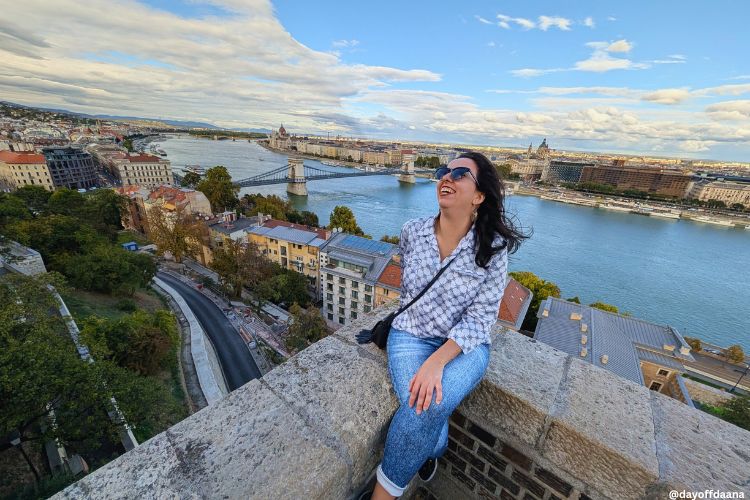 Estou no meio da foto, dando risada. Atrás de mim, você vê o rio Danúbio e o Parlamento. Estou no complexo do Castelo de Buda, uma ótima opção do que fazer em Budapeste.