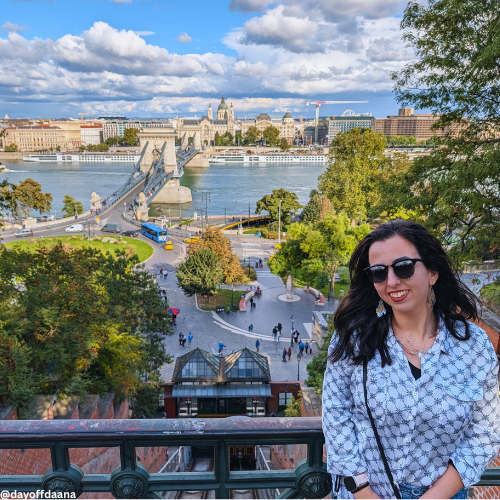 Na frente, eu; ao fundo, o funicular de Buda, a ponte e o lado Peste — uma vista clássica de deve estar na sua lista de o que fazer em Budapeste!